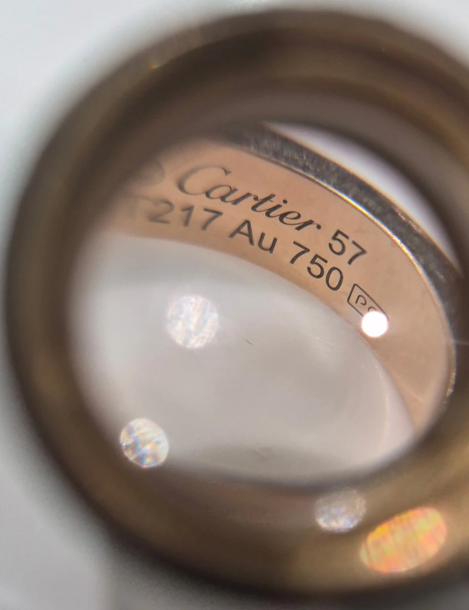 Cartier ring hallmark examined under a jeweler's loupe
